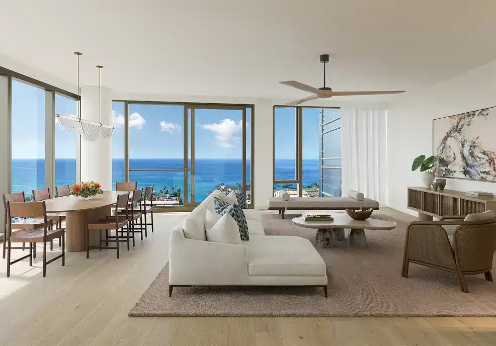 A modern living and dining room with large windows, light wood floors, neutral furniture, and an ocean view.