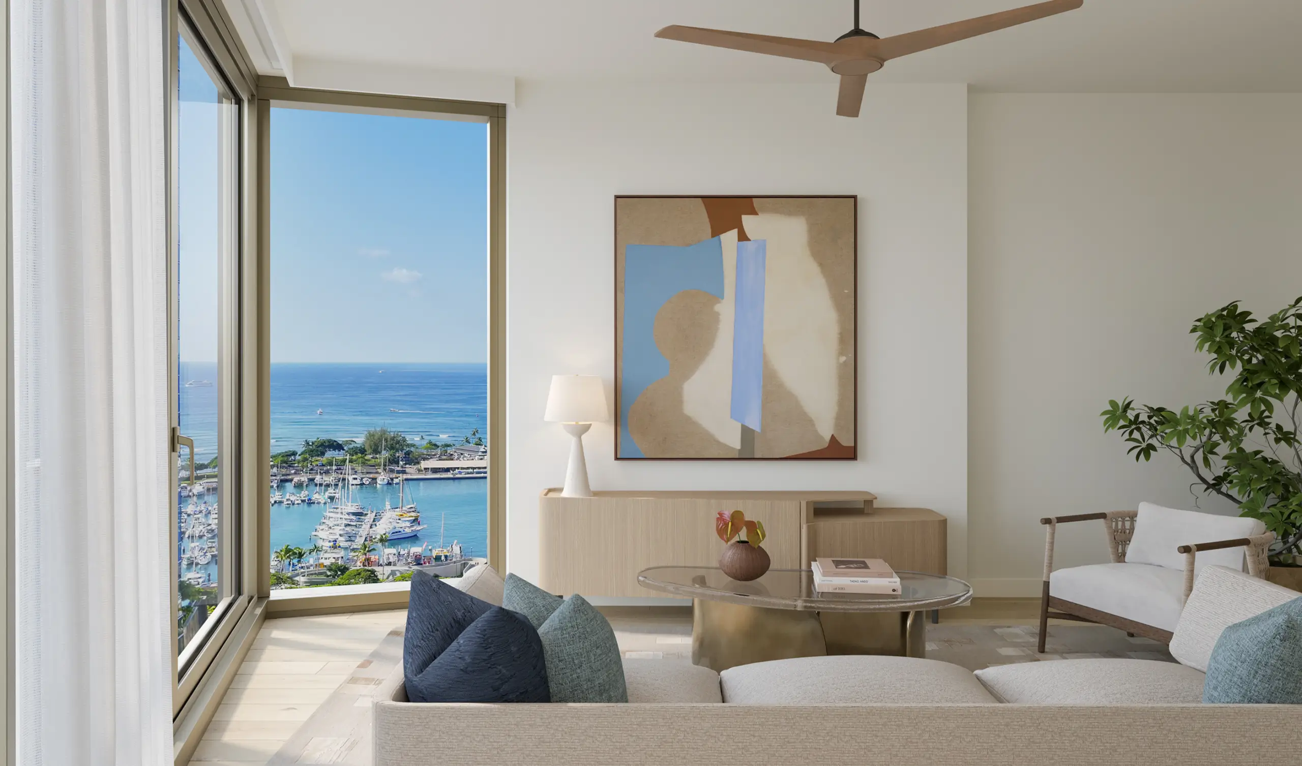A modern living room with large windows overlooks a marina and ocean. The room features neutral furniture, abstract wall art, a ceiling fan, and a potted plant.